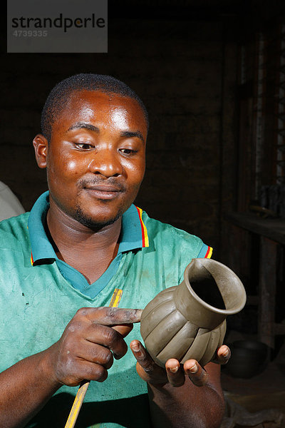 Mann mit Tonvase  Herstellung von Töpfereiprodukten  Bamessing  Kamerun  Afrika