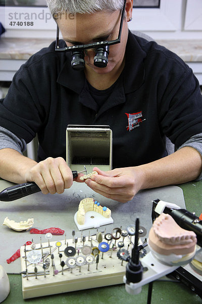 Zahntechnisches Labor  Herstellung von Zahnersatz durch einen Meisterbetrieb  Beschleifen  Separieren einer keramisch verblendeten Zahnbrücke  Lupenbrille