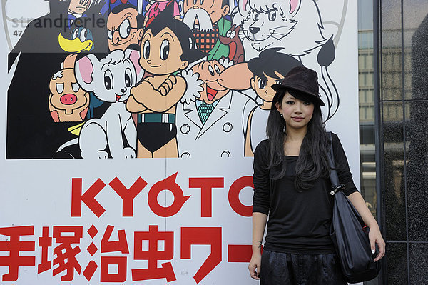 Japanerin mit einem typisch modischen Hut vor einem Plakat für Kyoto  Bahnhof  Kyoto  Japan  Asien
