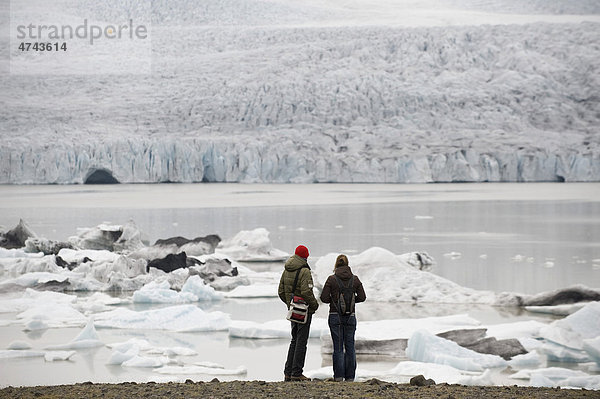 Touristen bewundern die Eisberge die in der Gletscherlagune Brei_alÛn treiben  Südisland  Island  Europa
