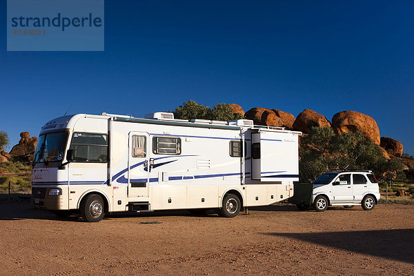 Campingbus mit angehängtem Auto am Campingplatz  Devils Marbles  Northern Territory  Australien