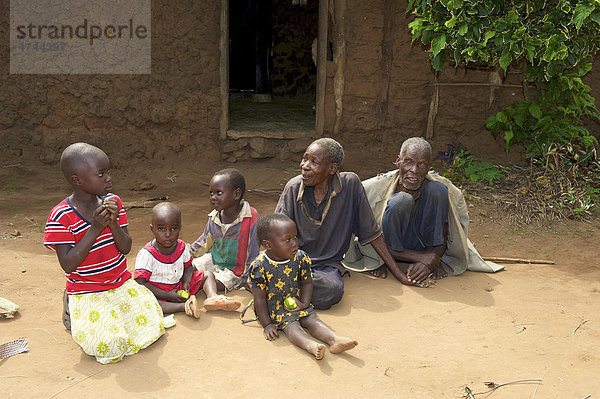Familie vor einem traditionellen Lehmhaus in der Nähe von Bukoba  Tansania  Afrika