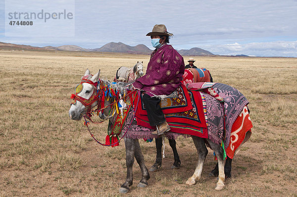 Traditionell gekleidete tibetanische Reiter entlang der Straße von Gerze nach Tsochen  Westtibet  Tibet  Asien