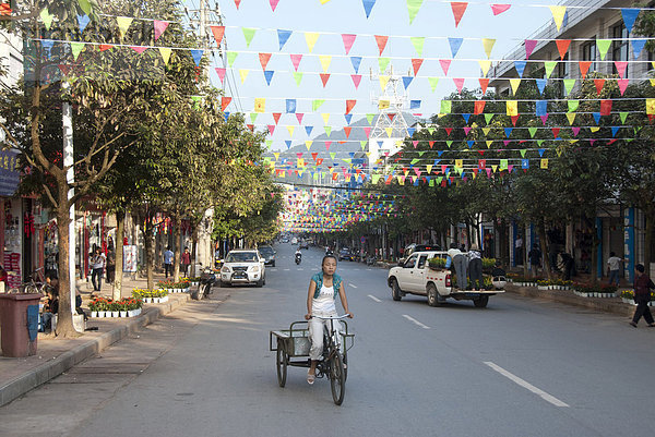 Radfahrerin auf der Straße  Jiangcheng  Stadt Pu'er  Provinz Yunnan  Volksrepublik China  Südostasien  Asien