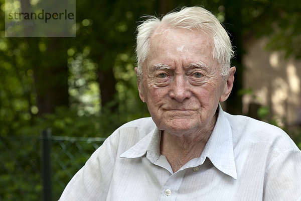 Freundliches Portrait eines alten  88 jährigen Mannes mit weißem Haar im Garten  Altenheim  Seniorenheim  Berlin  Deutschland  Europa