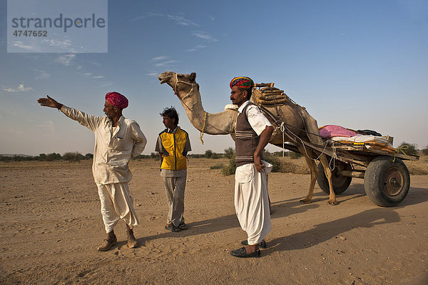 Zwei Inder  unterwegs mit Kamel und Kamelkarren  lassen sich von einem Ortskundigen den Weg erklären  Wüste Thar  Rajasthan  Indien  Asien