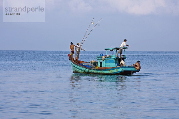 Ein Fischer holt auf seinem Boot sein ausgelegtes Netz mit dem Fischfang aus dem Meer herein  Insel Phu Quoc  Vietnam  Südostasien