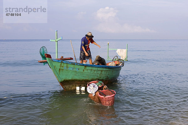 Fischer tragen Körbe mit gefangenem Fisch zu einem Boot  Insel Phu Quoc  Vietnam  Asien