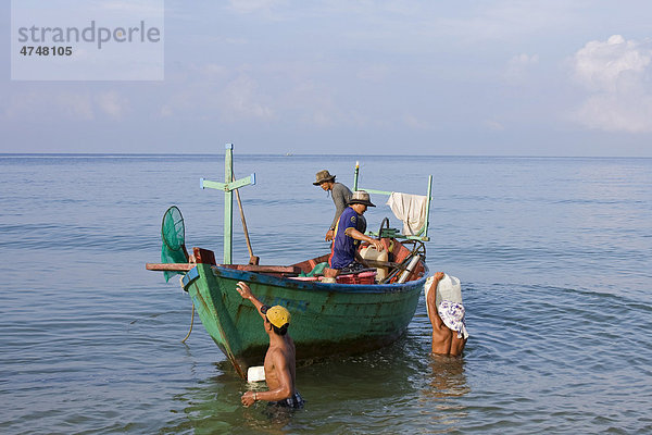 Fischer tragen Körbe mit gefangenem Fisch zu einem Boot  Insel Phu Quoc  Vietnam  Asien
