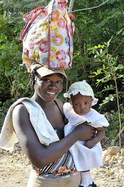 Portrait einer Mutter mit Kind  Mutter trägt eine Tasche auf dem Kopf  Petit Goave  Haiti  Karibik  Zentralamerika