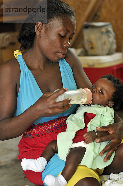 Mutter  31 Jahre  füttert ihren Sohn  3 Monate  mit der Flasche  Petit Goave  Haiti  Karibik  Zentralamerika