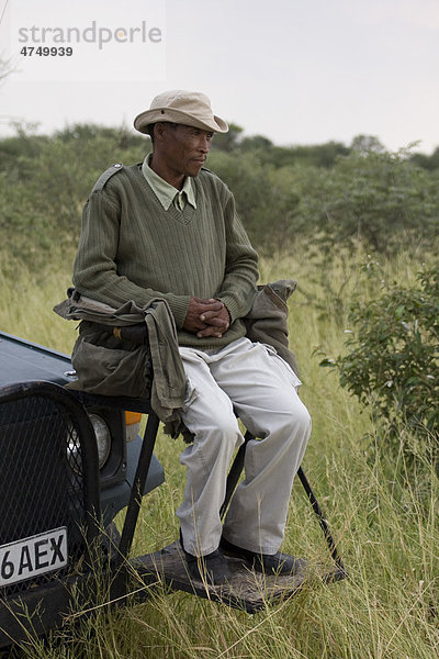 San Buschmann Trekker sitzt auf dem Kühler des Fahrzeugs  Botswana  Afrika