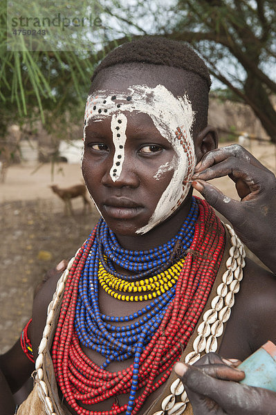 Junge Karo Frau beim Auftragen von Make-up  Gesichtsbemalung  Omo-Tal  Südäthiopien  Äthiopien  Afrika
