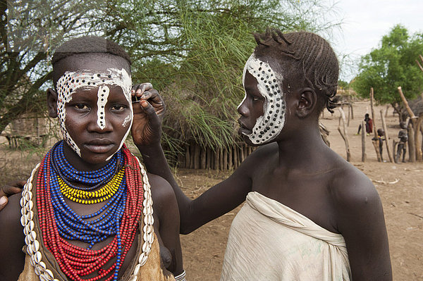 Junge Karo Frau beim Auftragen von Make-up  Gesichtsbemalung  Omo-Tal  Südäthiopien  Äthiopien  Afrika