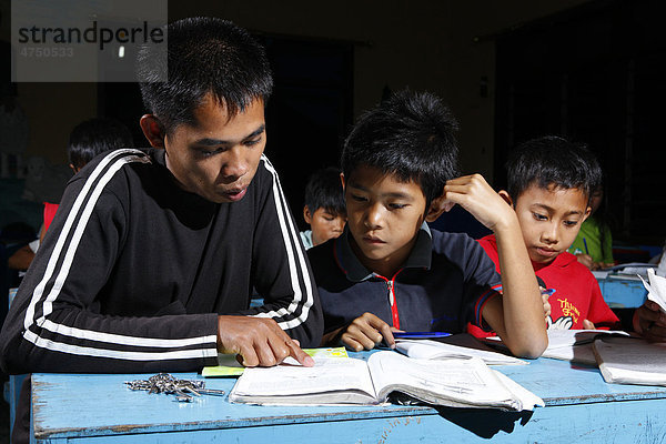 Jungen beim Lernen  Jugendlicher gibt Nachhilfe  Waisenhaus Gelora Kasih  Kabanjahe  Batak Region  Sumatra  Indonesien  Südostasien  Asien