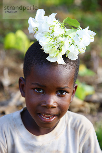 Junge  6 Jahre  mit Blumen auf dem Kopf  Kamachumu  Kagera Region  Tansania  Afrika