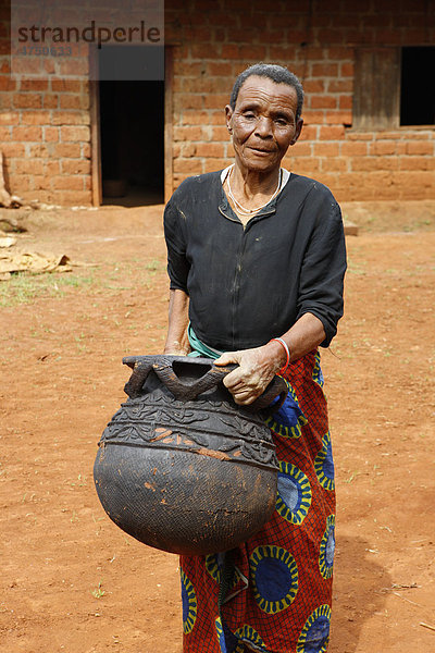 Frau trägt Steingutgefäß  Herstellung traditioneller Töpferware  Babessi  Kamerun  Afrika