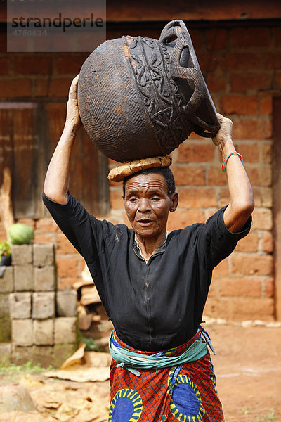 Frau trägt Steingutgefäß  Herstellung traditioneller Töpferware  Babessi  Kamerun  Afrika