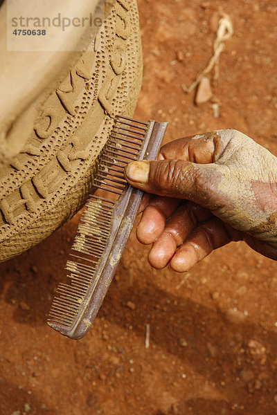 Frau verziert mit einem Kamm traditionelle Töpferware  Babessi  Kamerun  Afrika