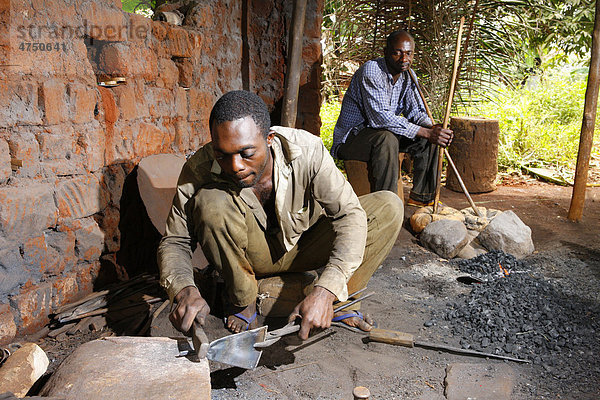 Schmied bearbeitet Altmetall zu Musikinstrument  Mann mit Blasebalg  Babungo  Kamerun  Afrika