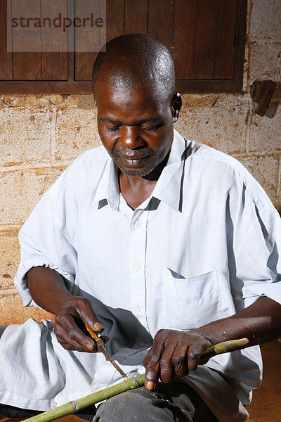 Mann bei der Herstellung einer Bambuspfeife  Bafut  Kamerun  Afrika