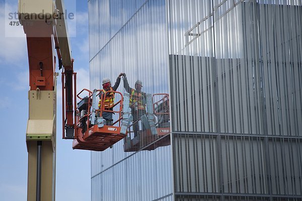 Männlich Glazer installiert Glas FOM ein Mann den Auftrieb an der Außenseite des Anchorage Museum zusätzlich während der Bauphase  Anchorage  Südalaska  Frühling