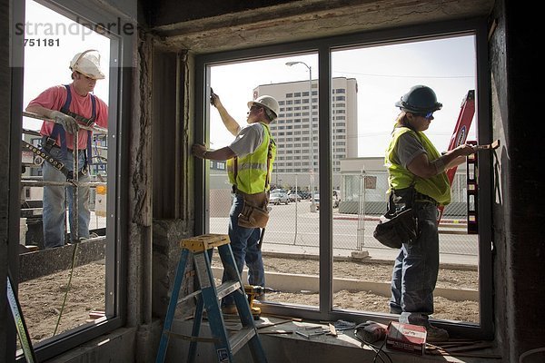 Tischler installieren Fensterrahmen bei der Renovierung von Wohnungen McKinley Tower (ehemals MacKay-Gebäude) in der Innenstadt von Anchorage  Südalaska  Sommer