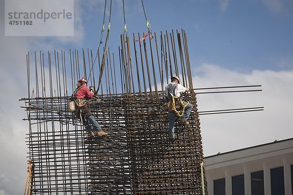 Zwei Bauarbeiter installieren Bewehrungsstahl für ein neues Gebäude an der Northern Lights Blvd. und C Street  Anchorage  Südalaska  Sommer