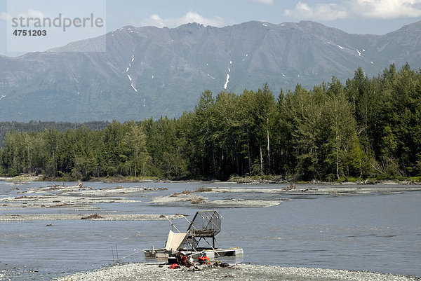 Zwei Männer entspannen auf einer Kiesbank neben einem Aluminium Fisch Rad auf der Matanuska River  Mat-Su Valley  Südalaska  Sommer