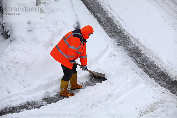 Gehweg wird von einem Hausmeisterdienst  Serviceunternehmen  vom Schnee geräumt  Essen  Nordrhein-Westfalen  Deutschland  Europa