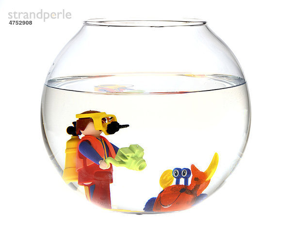 Spielzeugfigur  Taucher  mit Unterwasserkamera und einer Krabbe  in einem Goldfischglas  Illustration