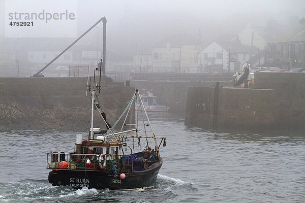 Fischkutter fährt bei Nebel in den Hafen  Porthleven  Cornwall  England  Großbritannien  Europa
