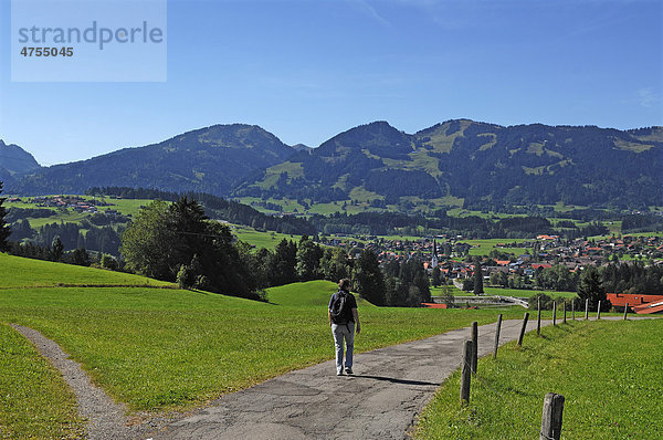 Blick auf Fischen  hinten Allgäuer Berge  vorne Wanderweg mit Wanderer  Schöllang  Allgäu  Bayern  Deutschland  Europa