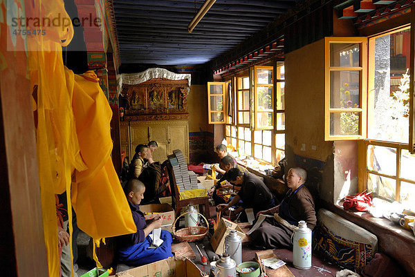 Tibetische Nonnen sitzen im Nonnenkloster Ani Tsakum  Ani Tsakung  bei der Arbeit und Herstellung der Texte zur Füllung tibetischer Gebetsmühlen  Gebetszylinder  Lhasa  Tibet  China  Asien
