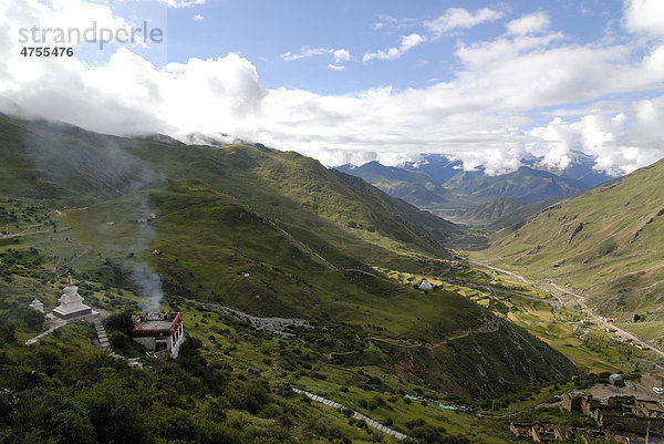 Tibetische Chörten  Stupa  mit Blick auf das Kyichu-Flusstal beim Felsenkloster Drak Yerpa bei Lhasa mit tibetischem Dorf  Tibet  China  Asien