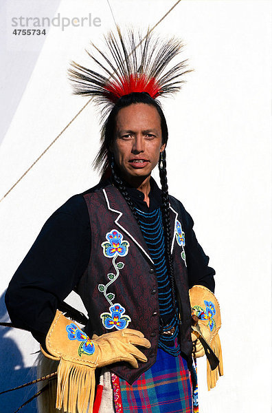 Amerikanischer Ureinwohner in zeremonieller Kleidung vor einem Indianerzelt oder Tipi  USA