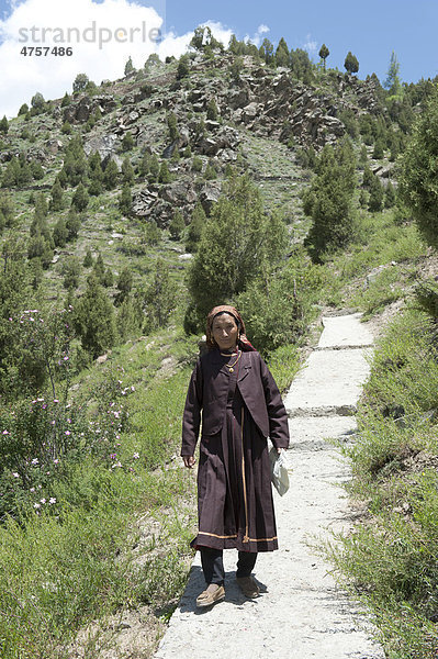 Frau in Tracht geht auf dem Pfad hinunter vom Kloster Shashur Gompa  Keylong  Distrikt Lahaul und Spiti  Bundesstaat Himachal Pradesh  Indien  Südasien  Asien