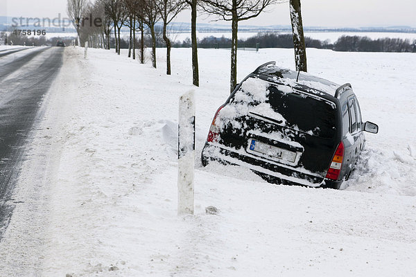Ein Pkw steckt in einer Schneewehe fest  Winter  Deutschland