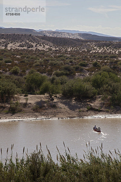 Mexikaner aus dem Dorf Boquillas del Carmen überqueren den Rio Grande in einem Kanu  der Fluss bildet die Grenze zwischen den USA und Mexiko  sie überqueren illegal den Fluss um ihre kunsthandwerklichen Waren an Touristen zu verkaufen  und das  obwohl Touristen die diese Waren kaufen von der US-Einwanderungsbehörde strafrechtlich verfolgt werden  Big-Bend-Nationalpark  Texas  USA
