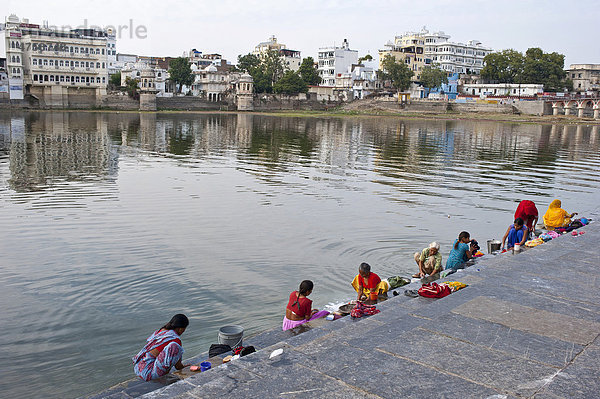 Indische Frauen waschen am Ufer  Ghat  des Pichola-See ihre Wäsche  Udaipur  Rajasthan  Indien  Asien
