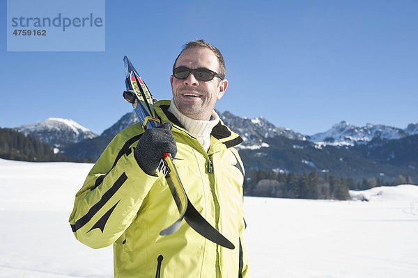 Mann mit Skiern in Winterlandschaft  Tannheimer Tal  Tirol  Österreich