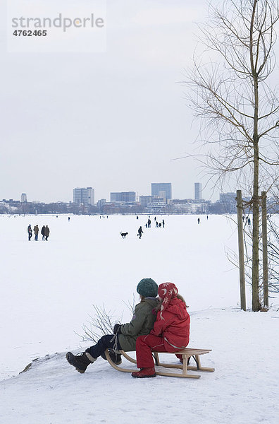 Kinder beim Schlittenfahren an der zugefrorenen Alster  Hamburg  Deutschland  Europa