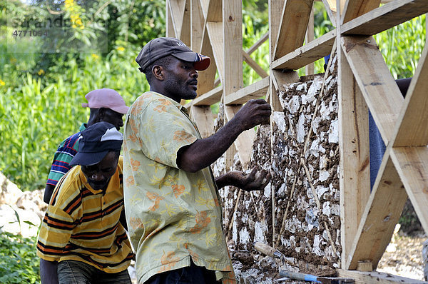 Nach dem schweren Erdbeben im Januar 2010 bildet eine deutsche Hilfsorganisationen lokale Bauarbeiter im Bau erdbebensicherer Häuser aus. Die Häuser bekommen eine Fachwerkstruktur aus Holz  die mit Lehm und Feldsteinen ausgefüllt wird  Dorf Coq Chante nahe Jacmel  Haiti  Karibik  Zentralamerika