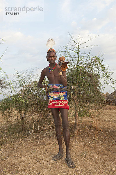Hamar Krieger mit typischer Lehm Haarfrisur und Feder  mit Gewehr und Kopfstütze  Omo-Tal  Süd Äthiopien  Afrika