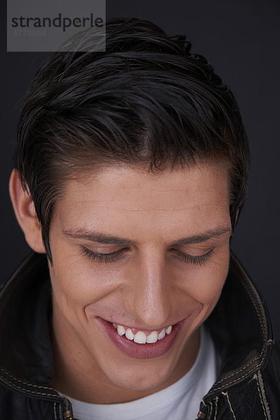 Junger Mann mit strahlend weißen Zähnen lächelt  Porträt