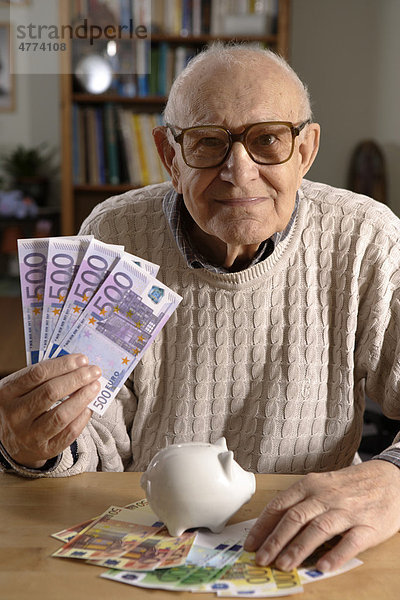 Alter Mann  Senior  92 Jahre  mit Sparschwein und Eurobanknoten