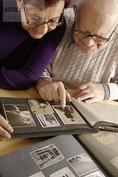 Alter Mann  Senior  92 Jahre  und Tochter  schauen sich ein Familienalbum an