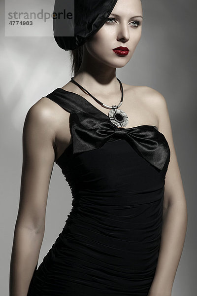 Junge Frau mit eleganter Mütze und schwarzem Kleid  Porträt