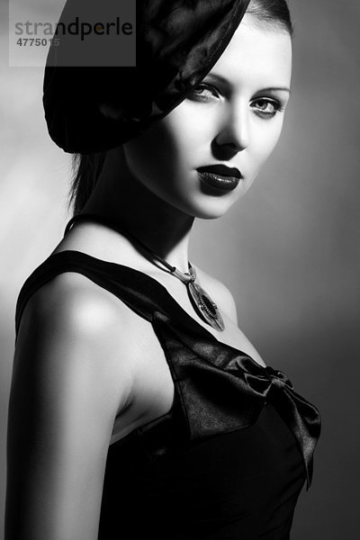 Junge Frau mit eleganter Mütze und schwarzem Kleid  Porträt  schwarz-weiß