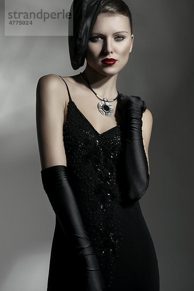 Junge Frau mit eleganter Mütze und schwarzem Kleid